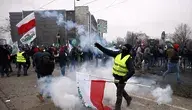 Polski rolnik z biało-czerwoną flagą na ulicy w Strasburgu  podczas protestu rolników.