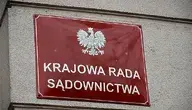 Czerwona tablica informacyjna przy wejściu do budynku Krajowej Rady Sądownictwa.