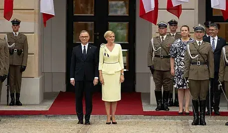 Para prezydencka na tle Pałacu Prezydenckiego w asyście żołnierzy