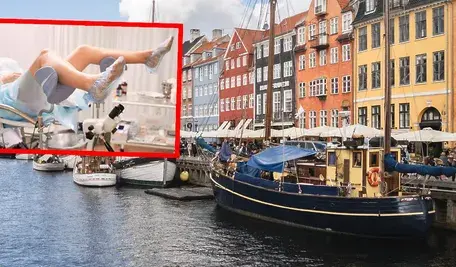 Pacjentka na fotelu ginekologicznym podczas badania w gabinecie lekarskim, wmontowana w czerwonej ramce w zdjęcie kolorowej zabudowy nad kanałem w centrum skandynawskiego miasta portowego.