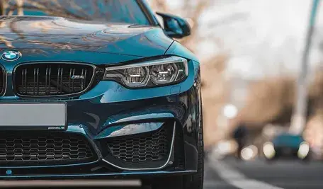 Samochód marki BMW w pięknym turkusowym kolorze porusza się drogą przez świat, ma już letnie opony wymienione w zakładzie Inter Cars
