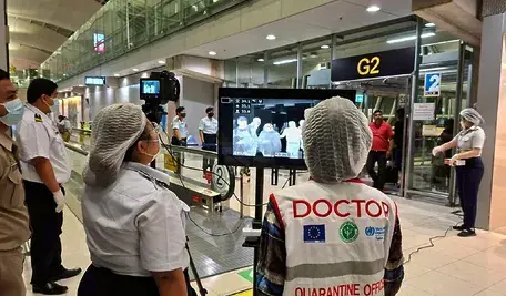 Zdjęcie przedstawia tajskich urzędników służby zdrowia w maseczkach ochronnych, monitorujących pasażerów przylatujących międzynarodowymi lotami na lotnisku Suvarnabhumi w Tajlandii 25 stycznia 2026 r. Wprowadzono screening zdrowotny dla lotów z Bengalu Zachodniego w Indiach w celu zapobiegania rozprzestrzenianiu się wirusa Nipah. Kontrole na lotniskach Suvarnabhumi i Don Mueang rozpoczęły się po doniesieniach o ognisku epidemii. Zdjęcie: EPA/THE SUVARNABHUMI AIRPORT OFFICE / PAP.