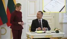 Prezydent Karol Nawrocki składa podpis pod księgą w WIlnie