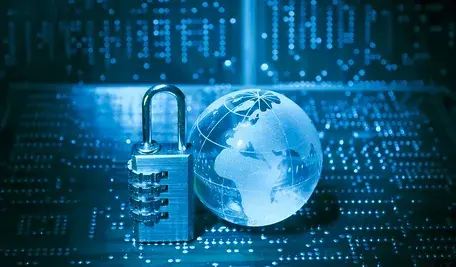 Kłódka stojąca obok przezroczystej kuli ziemskiej na tle cyfrowych danych