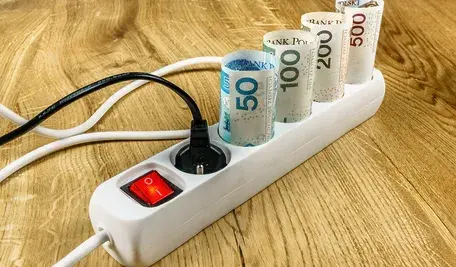 Ceny prądu w Polsce są bardzo wysokie. A będzie jeszcze gorzej. Na zdjęciu widzimy banknoty włożone w listwę energetyczną, co pokazuje, jak drogi jest prąd w Polsce rządzonej przez Donalda Tuska i jego ekipę