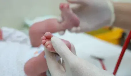 Stopy noworodka w rękach lekarza. To rutynowe badanie