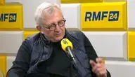 Marek Siwiec, nowy szef Kancelarii Sejmu, w studiu RMF FM z żółtym mikrofonem stacji, gestykuluje energicznie podczas Porannej rozmowy. Siedzący mężczyzna w okularach, czarnej bluzie i kamizelce, otoczony żółto-białym tłem z logo RMF24 i RMF FM, komentuje politykę USA i współpracowników prezydenta Nawrockiego. Zdjęcie z 7 stycznia 2026 r. ilustruje viralowe wypowiedzi o "Ameryce z kasetem" i "bulterierze Boguckim". 