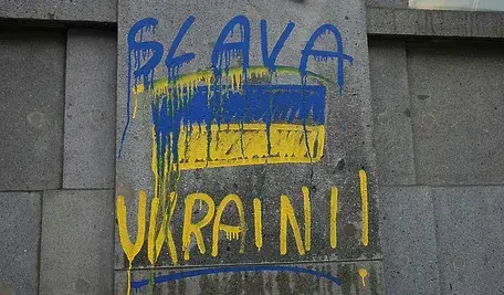 Żółto-niebieski napis "Slava Ukraini" na budynku