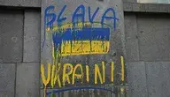 Żółto-niebieski napis "Slava Ukraini" na budynku