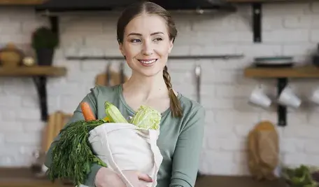 positive-young-woman-holding-bag-with-organic-vegetables (1)