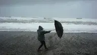 Człowiek z parasolem na plaży