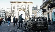 People walk past a burnt out car in the aftermath of clashes between riot police and demonstrators in Paris, France, during nationwide protests against the high cost of living in the country, 18 October 2026. EPA/MOHAMMED BADRA Dostawca: PAP/EPA.