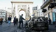 People walk past a burnt out car in the aftermath of clashes between riot police and demonstrators in Paris, France, during nationwide protests against the high cost of living in the country, 18 October 2026. EPA/MOHAMMED BADRA Dostawca: PAP/EPA.