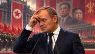 Donald Tusk przy mównicy na tle czerwonych flag, wojskowej defilady i portretów przywódców Korei Północnej – satyryczna ilustracja do artykułu o mediach publicznych.
