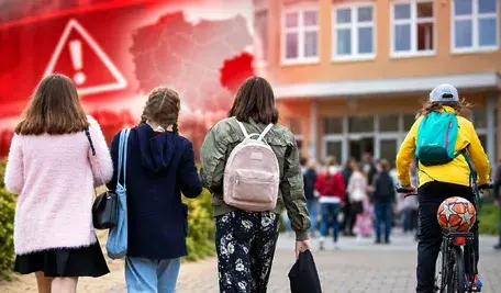 Dzieci idące do szkoły na tle symbolu alarmu ostrzegawczego – ilustracja kontrowersji wokół procedur bezpieczeństwa w placówkach oświatowych