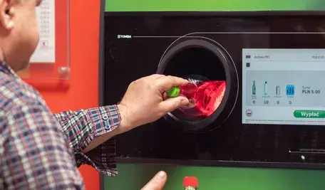 Mężczyzna zwracający plastikowe butelki