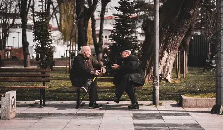 Starsi mężczyźni siedzący na ławce w parku
