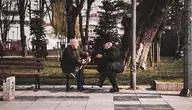 Starsi mężczyźni siedzący na ławce w parku