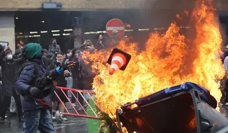 Protesters throw items into a fire during a demonstration organized by national trade unions against the federal government's planned economic and wage reforms in Brussels, Belgium, 09 October 2026. Students have joined workers in the protest after a week of demonstrations against education reforms across Belgium, some of which have led to violent clashes with police