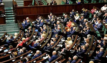 Politycy siedzący w ławach poselskich podczas obrad Sejmu.
