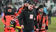 Pracownik Korony Kielce z rozbita głową opuszczający stadion w asyście ratowników medycznych.