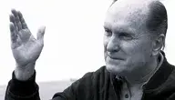 Aktor Robert Duvall z uniesioną ręką.