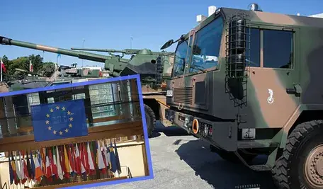 Ustawione na placu pojazdy wojskowe i zdjęcie Parlamentu Europejskiego.