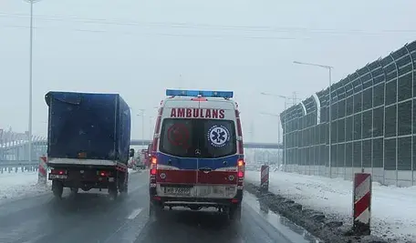 Karetka pogotowia jadąca zimą autostradą.