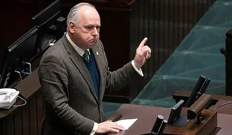 Wiceszef MON Paweł Zalewski gestykuluje przy mównicy sejmowej