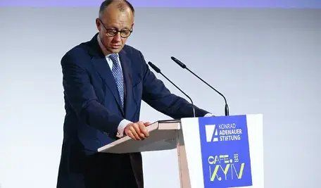 Friedrich Merz, kanclerz Niemiec, podczas konferencji prasowej. Widoczny mikrofon i skupiona sylwetka lidera CDU, którego wypowiedź o „Rosji jako największym sąsiedzie” wywołała ostrą reakcję posła Pawła Jabłońskiego.