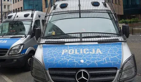 Policyjny radiowóz na ulicy. W tle sprawa zatrzymania funkcjonariusza