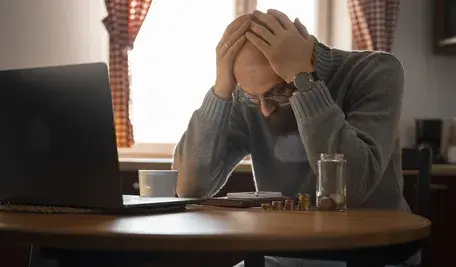 Mężczyzna załamany nad stołem