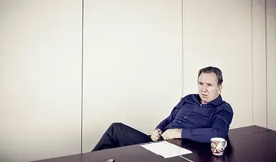 Biznesmen Michał Sołowow siedzący za biurkiem.