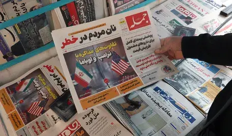 Okładka gazety z flagami USA i Iranu.