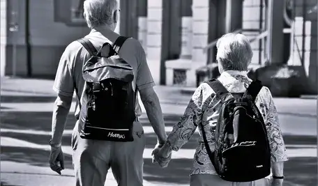 Dwoje seniorów spacerujących trzymając się za ręke