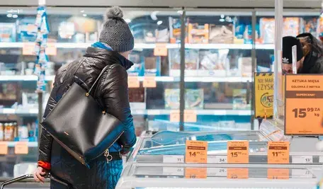 Polskie sery nie podobają się ukraińskim producentom. Kobieta przy kasie patrzy na jedzenie w lodówce