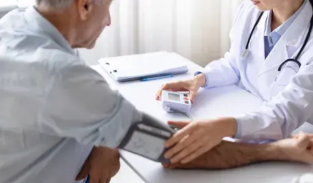 Lekarz mierzy ciśnienie, pacjent się boi, że wynik będzie wysoki. 