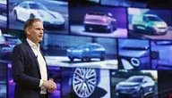 Na zdjęciu jeden z szefów grupy Volkswagen na tle prospektów i ekranów prezentujących samochody grupy, tekst dotyczy słabych wyników Porsche