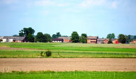 Hałdy ziemi z wykopów składowane na prywatnej działce – materiał budowlany, który w świetle przepisów może zostać uznany za odpad i skutkować wysoką karą finansową.