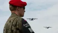 Funkcjonariusz Żandarmerii Wojskowej, w tle dwa lecące samoloty