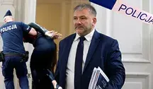 Minister sprawiedliwości Waldemar Żurek , obok taśma policyjna i policjant podczas zatrzymania.