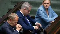 Donald Tusk siedzący na sali sejmowej w towarzystwie Krzysztofa Gawkowskiego i Barbary Nowackiej.
