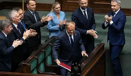 Premier Donald Tusk oklaskiwany na sali sejmowej przez członków rządu.