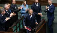 Premier Donald Tusk oklaskiwany na sali sejmowej przez członków rządu.
