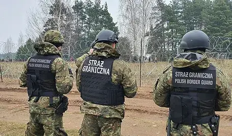 Trzech strażników podczas patrolu na polskiej granicy.