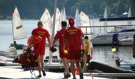 Ratownicy wodni niosący sprzęt ratowniczy