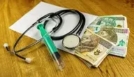 Koperta z pieniędzmi leżąca na stole razem ze strzykawką i stetoskopem