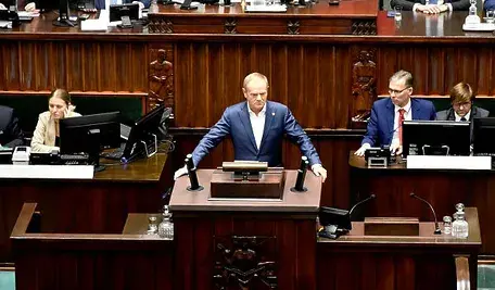 Donald Tusk stojący przy mównicy sejmowej