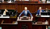 Donald Tusk stojący przy mównicy sejmowej