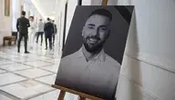 Czarno-Białe zdjęcie posła Łukasza Litewki ustawione na korytarzu sejmowym.